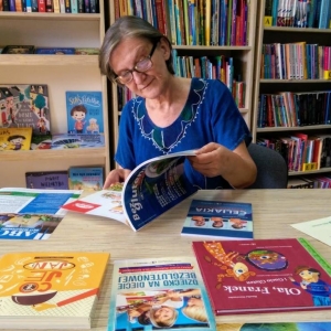 Pani Grażyna Bońkowska przeglądająca książki, które biblioteka wygrała w konkursie "Bezglutenowa Biblioteka"